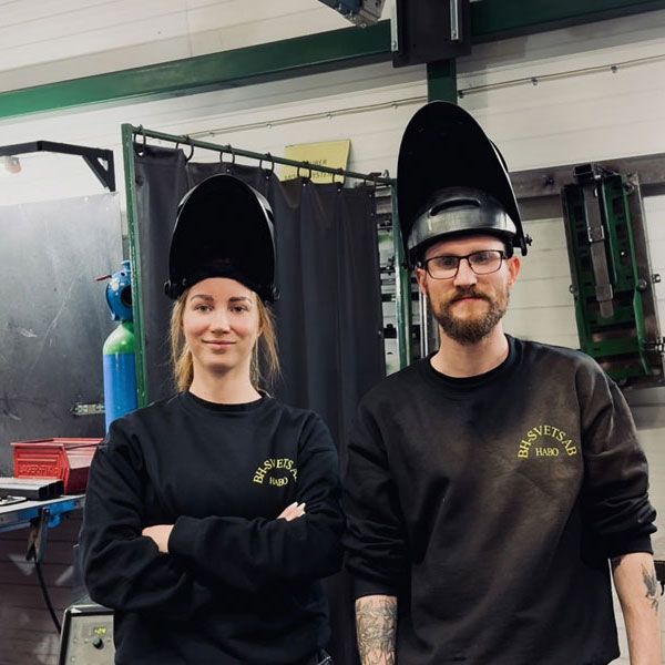 Två personer står och tittar mot kameran